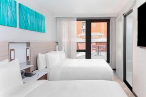 a hotel room with two beds and a balcony at SpringHill Suites by Marriott New York Manhattan/Times Square South in New York