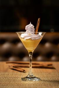 uma bebida com chantilly num copo sobre uma mesa em Novotel Curitiba Batel em Curitiba