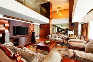 a living room with couches and a flat screen tv at Sheraton Xiamen Hotel in Xiamen