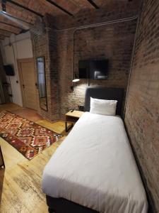 a large bed in a room with a brick wall at Novus Pera Hotel in Istanbul