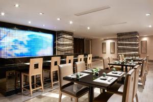 a dining room with tables and chairs and a large screen at Sheraton Shanghai Waigaoqiao Hotel in Shanghai