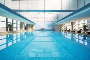 a large swimming pool with blue water in a building at Sheraton Shanghai Waigaoqiao Hotel in Shanghai