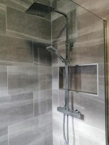 a shower with a glass door in a bathroom at The Snug Centre of Morpeth in Morpeth