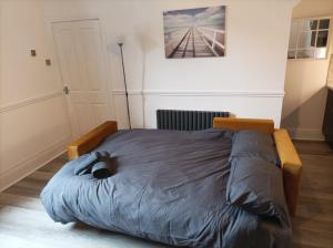 a bed in a bedroom with a cat laying on it at The Snug Centre of Morpeth in Morpeth