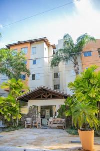 a building with a patio with chairs and trees at Lorenza by Paramar in Ubatuba