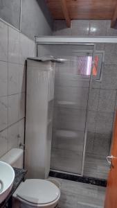 ein Bad mit einer Dusche, einem WC und einem Waschbecken in der Unterkunft Tierras de Shiva in Valle Hermoso