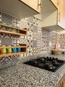 a kitchen with a stove and a tile wall at Résidence Miftah essahil anza agadir in Agadir