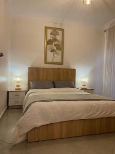 a bedroom with a large wooden bed with two lamps at Résidence Miftah essahil anza agadir in Agadir