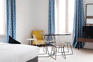 Pokój z łóżkiem, stołem i krzesłami w obiekcie Résidence Le Beau Rivage w mieście Bandol
