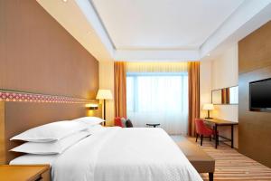 a hotel room with a bed and a desk at Four Points By Sheraton Guilin Lingui in Guilin