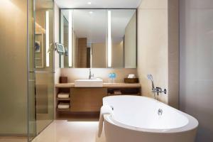 a bathroom with a tub and a sink and a mirror at Four Points By Sheraton Guilin Lingui in Guilin