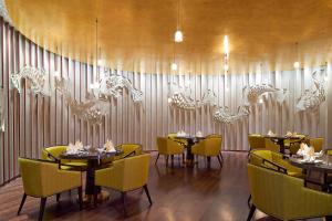 a dining room with tables and yellow chairs at Four Points By Sheraton Guilin Lingui in Guilin