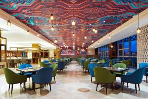 桂林Four Points By Sheraton Guilin Lingui的餐厅拥有色彩缤纷的天花板,配有桌椅