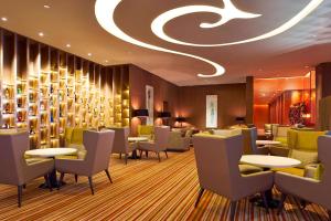 a restaurant with tables and chairs and a ceiling with a chandelier at Four Points By Sheraton Guilin Lingui in Guilin