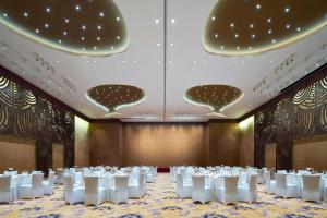 a banquet hall with white tables and white chairs at Four Points By Sheraton Guilin Lingui in Guilin