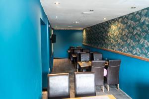 Severn View Hotel في وستر: غرفة طعام بجدران زرقاء وطاولات وكراسي
