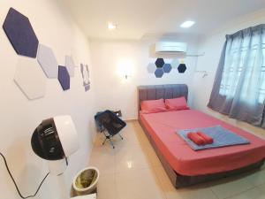 a bedroom with a red bed and a television at Lot 90 Seremban Town Homestay in Seremban