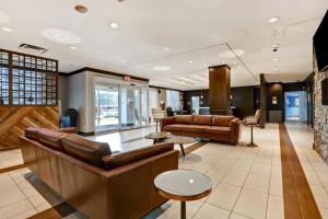 a lobby with leather couches and tables in a building at Four Points by Sheraton Toronto Mississauga in Mississauga