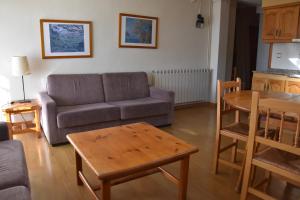 una sala de estar con un sofá y una mesa en Apartamentos SNÖ Edelweiss, en Cerler