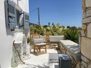 a patio with two chairs and cacti at LETIHOME Paros in Kampos Paros