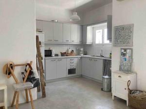 a kitchen with white cabinets and a refrigerator at LETIHOME Paros in Kampos Paros