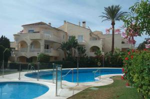 a large house with a swimming pool in front of it at Apartment near Puerto Banus in Estepona