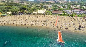 eine Luftansicht auf einen Strand mit Sonnenschirmen in der Unterkunft Sun Beach Villas in Foça