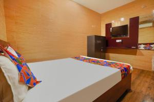 a hotel room with a bed and a tv at FabExpress Arunachala Guest House in Chennai