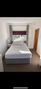 a large bed in a bedroom with a window at F17 Rickardos Holiday Lets in Mablethorpe