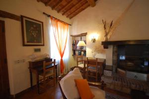 sala de estar con sofá, mesa y chimenea en Villa San Ansanino-Piscina privata en Pari