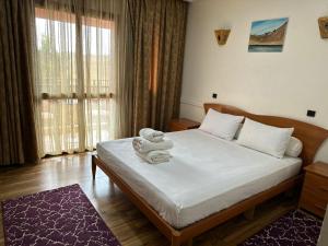Un dormitorio con una cama con un osito de peluche. en Amrouss touristic DarMaroc en Azrou