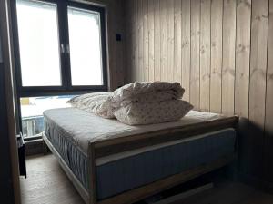 a bed sitting in a room with a window at Hafjell - Penthouse - ski in/out in Hafjell