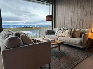 sala de estar con sofá, mesa y ventana grande en Hafjell - Penthouse - ski in/out, en Hafjell