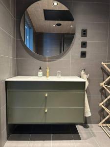 La salle de bains est pourvue d'un lavabo et d'un miroir. dans l'établissement Hafjell - Penthouse - ski in/out, à Hafjell