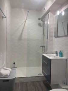 La salle de bains blanche est pourvue d'une douche et d'un lavabo. dans l'établissement Loire & Sérénité *T2* + Parking, à Orléans
