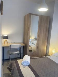 - une chambre avec un lit, un bureau et un miroir dans l'établissement Loire & Sérénité *T2* + Parking, à Orléans
