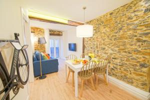 カストロ・ウルディアレスにあるArdigales Casco Antiguoのテーブルと石の壁のあるリビングルーム