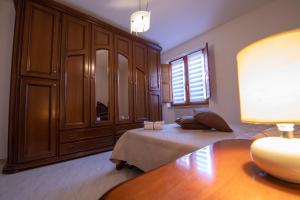 a bedroom with a bed and a large wooden cabinet at La Casa del Re - Apartments Buccino in Buccino +2 photos