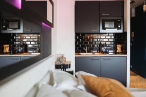 a kitchen with black cabinets and a sink in a room at LovRoz in Perros-Guirec