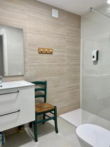 a bathroom with a chair and a sink and a shower at Bel Air Surf Escape in El Cotillo
