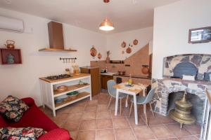 een keuken en een woonkamer met een tafel en een open haard bij La Casetta - Apartments Buccino in Buccino