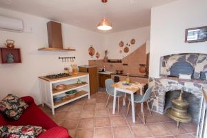 eine Küche und ein Wohnzimmer mit einem Tisch und einem Kamin in der Unterkunft La Casetta - Apartments Buccino in Buccino