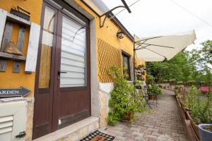 ein Gebäude mit einer Tür und einer Terrasse mit einem Sonnenschirm in der Unterkunft La Casetta - Apartments Buccino in Buccino