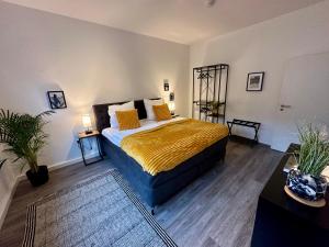 a bedroom with a bed with a yellow bedspread at ThreeRoom Gem of Essen in Essen
