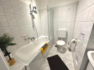 uma casa de banho branca com uma banheira e um WC em ThreeRoom Gem of Essen em Essen