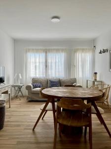 a living room with a table and a couch at Bel Air Surf Escape in El Cotillo