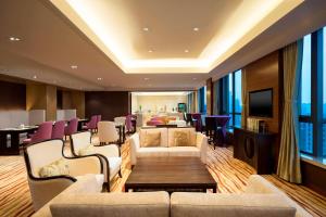 a waiting room with couches and chairs and a television at Four Points by Sheraton Hefei Shushan in Hefei