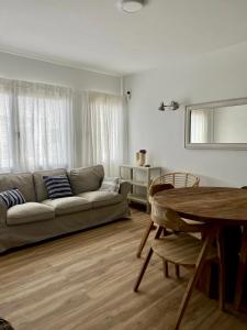 a living room with a couch and a table at Bel Air Surf Escape in El Cotillo +16 photos