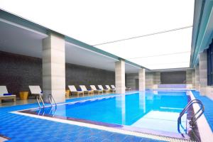 ein großer Pool in einem Hotel mit Stühlen in der Unterkunft Four Points by Sheraton Hefei Shushan in Hefei