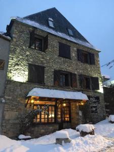 a large stone building with snow around it at Hotel SNÖ Mont Romies in Salardú